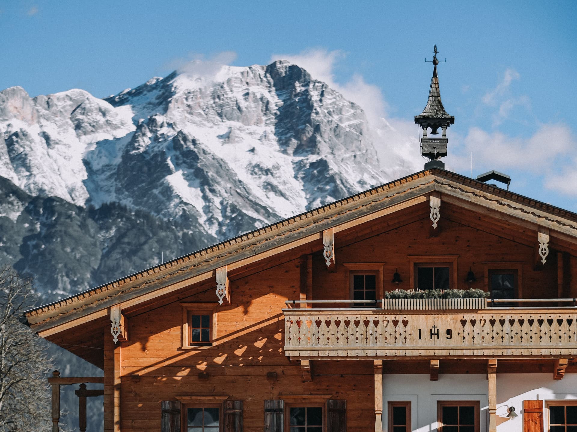 austrian-wooden-chalet-mountains-blue-sky