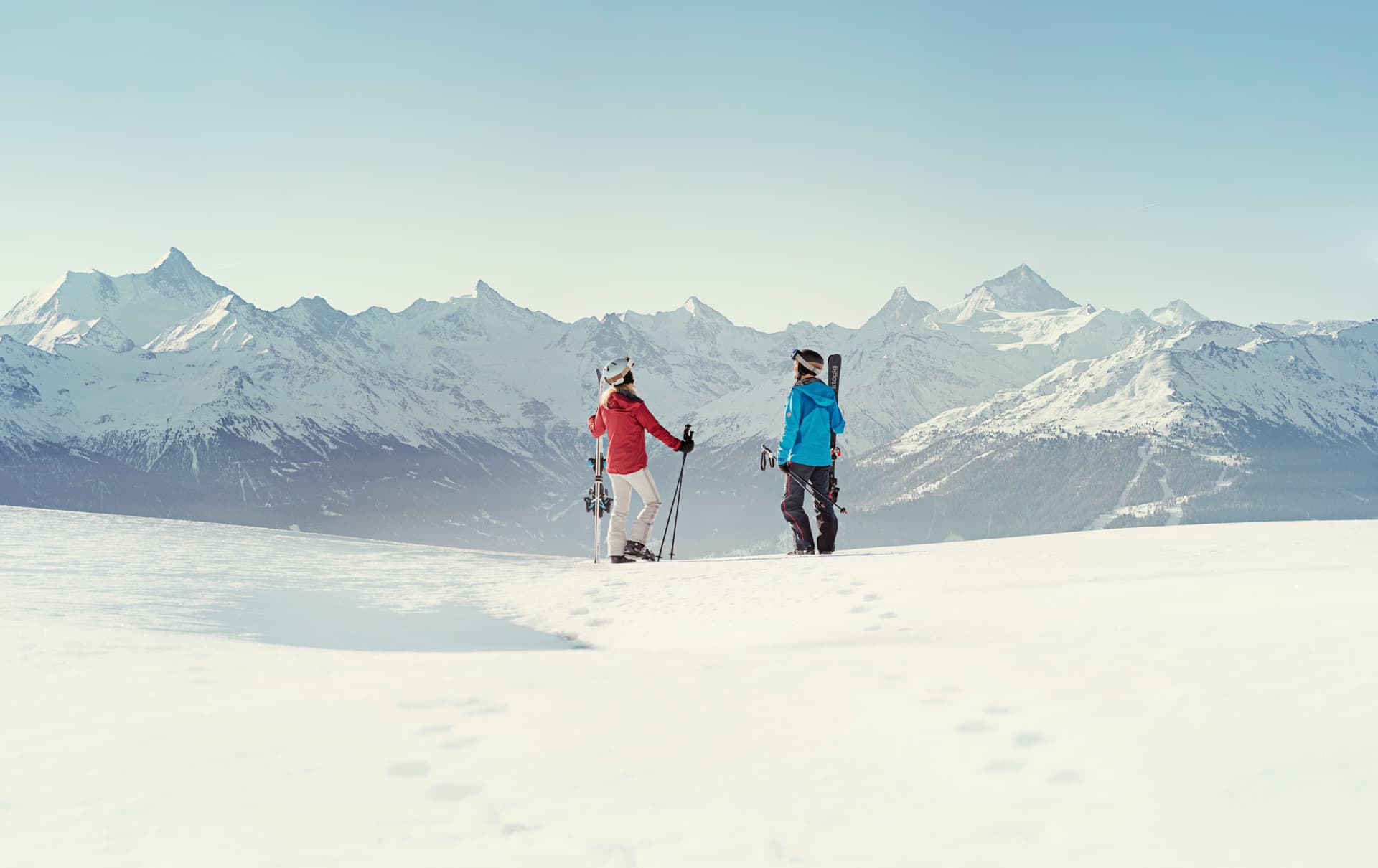 Couple taking break from skiing to admire view of Crans Montana ski resort
