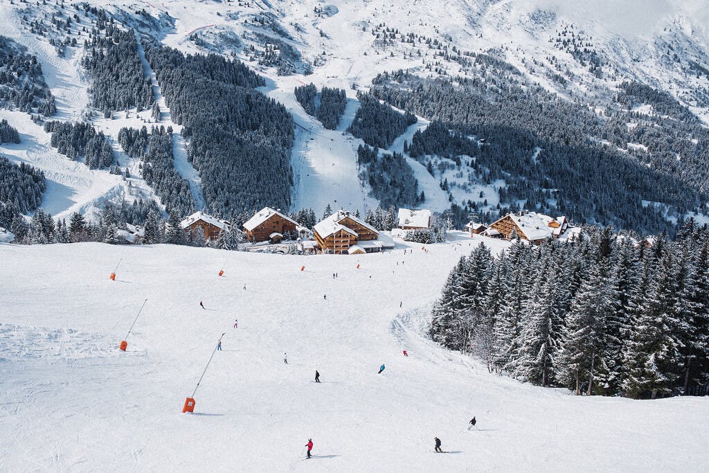 Skiiers skiing down wide open slope in Meribel France