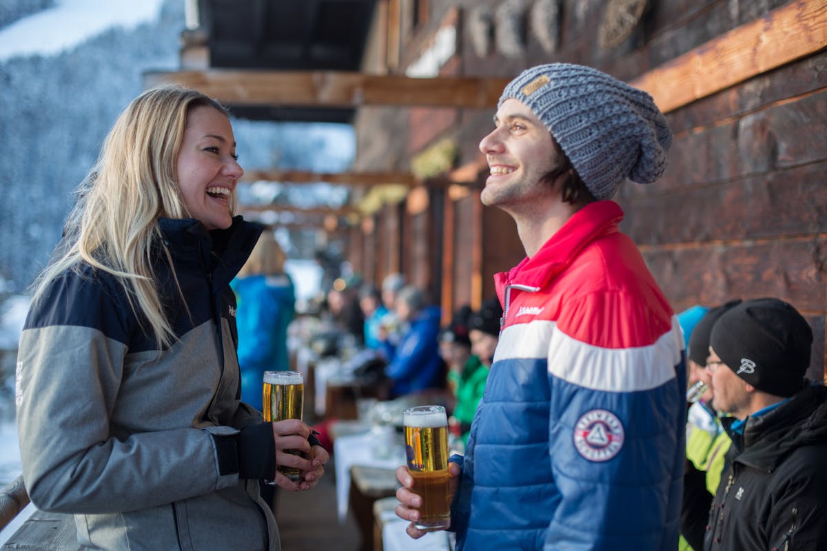 Couple enjoying an Apres ski beer in Austrian ski resort Saalbach Hinterglemm