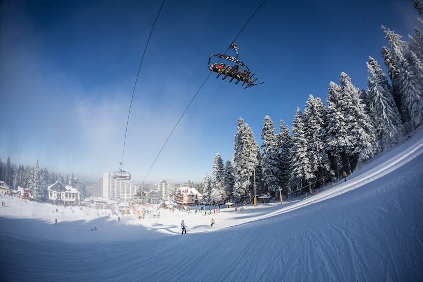 Skiers taking chairlift to top of mountain in Borvoets ski resort Bulgaria