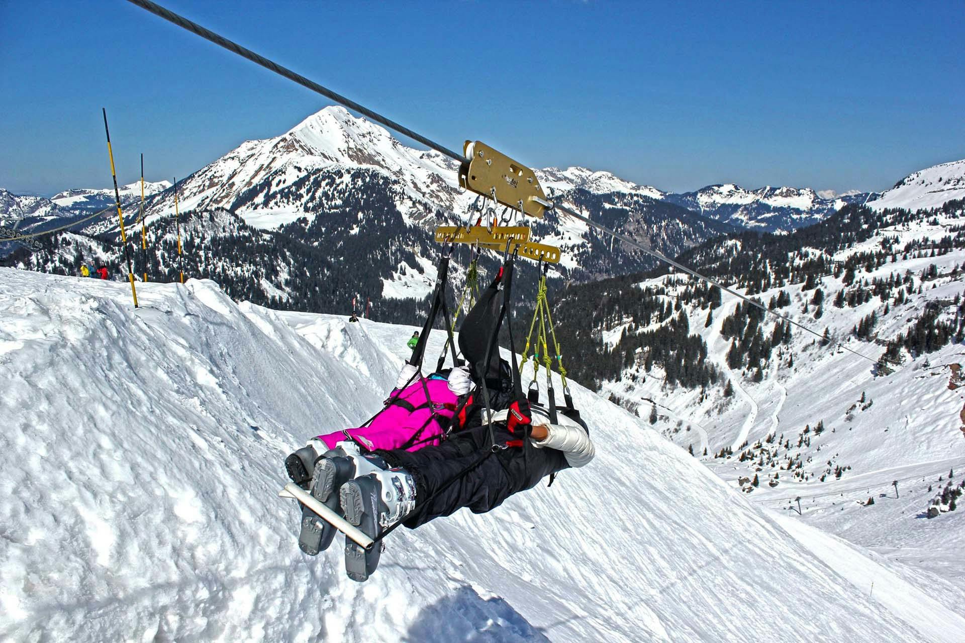 Couple enjoying zipline activity in winter ski resort Chatel