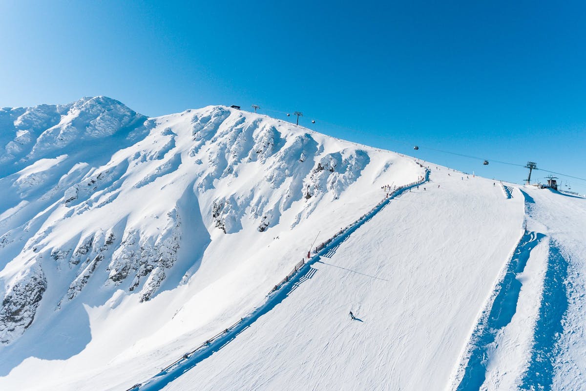 Lone skier carving down wide open ski slope