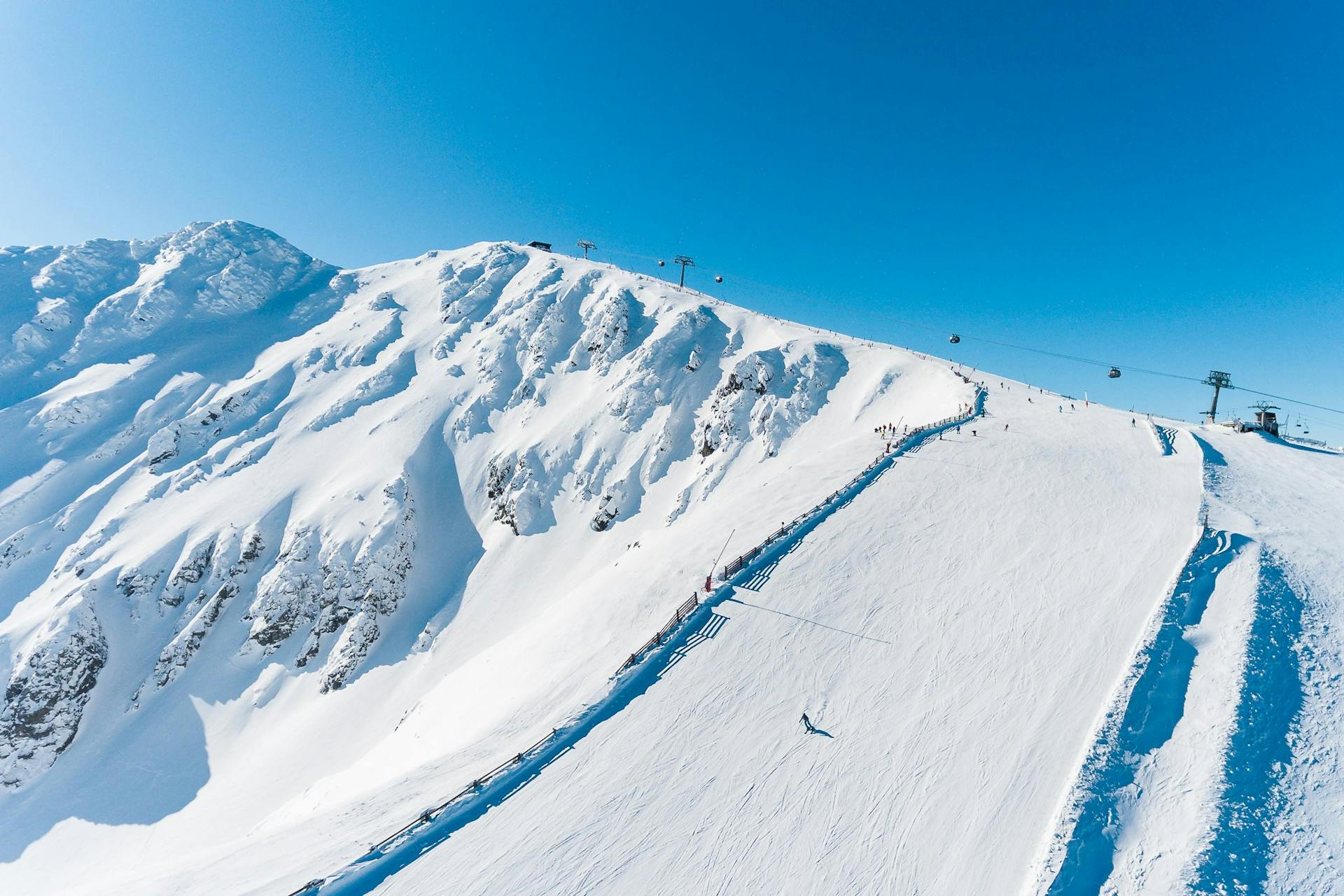 Lone skier carving down wide open ski slope