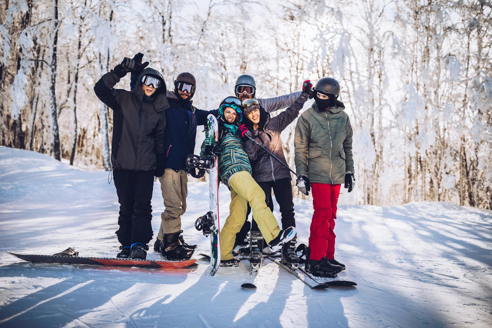 Group of friends skiers and snowboarders posing for photo