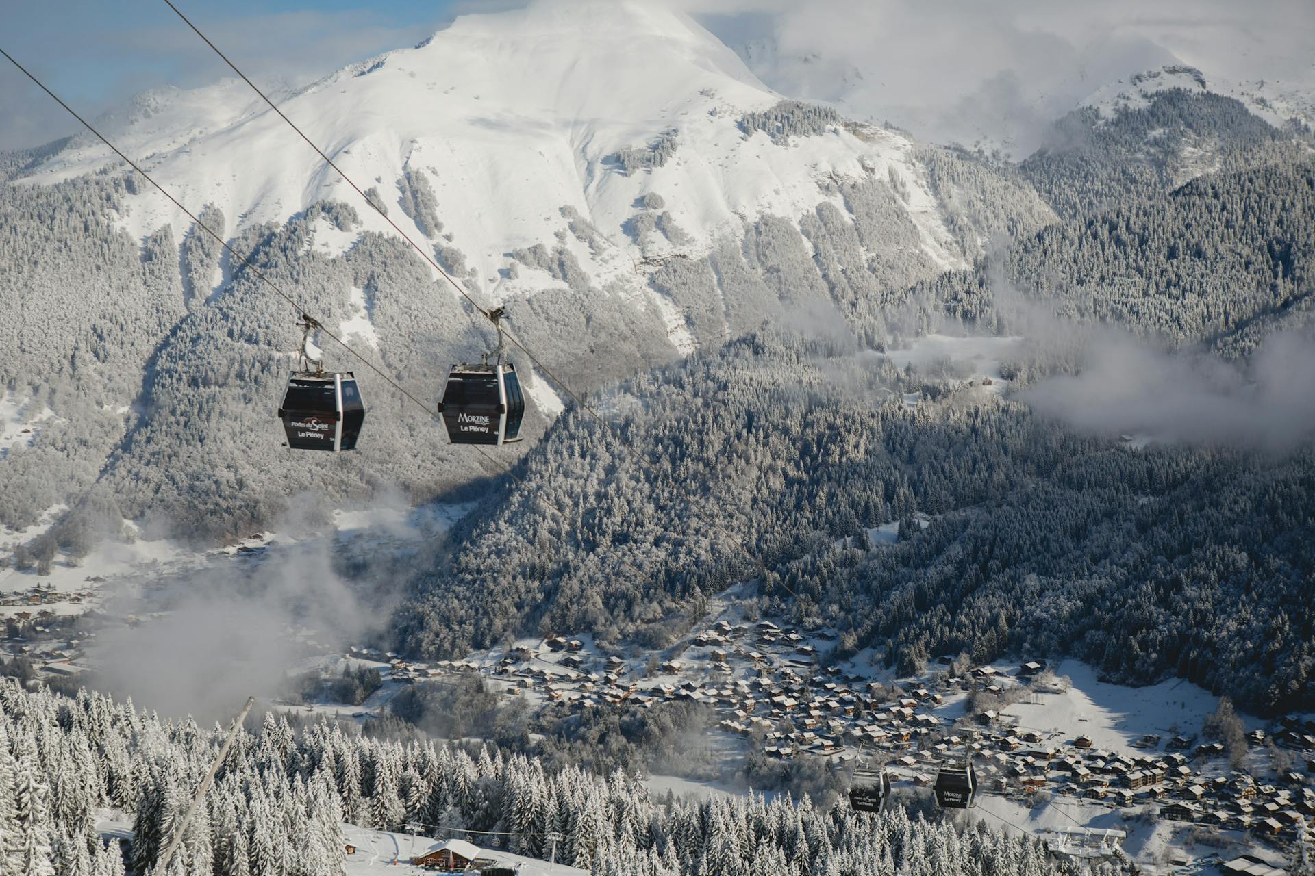 Gondolas taking skiiers to top of snowy mountain in Morzine French Alps