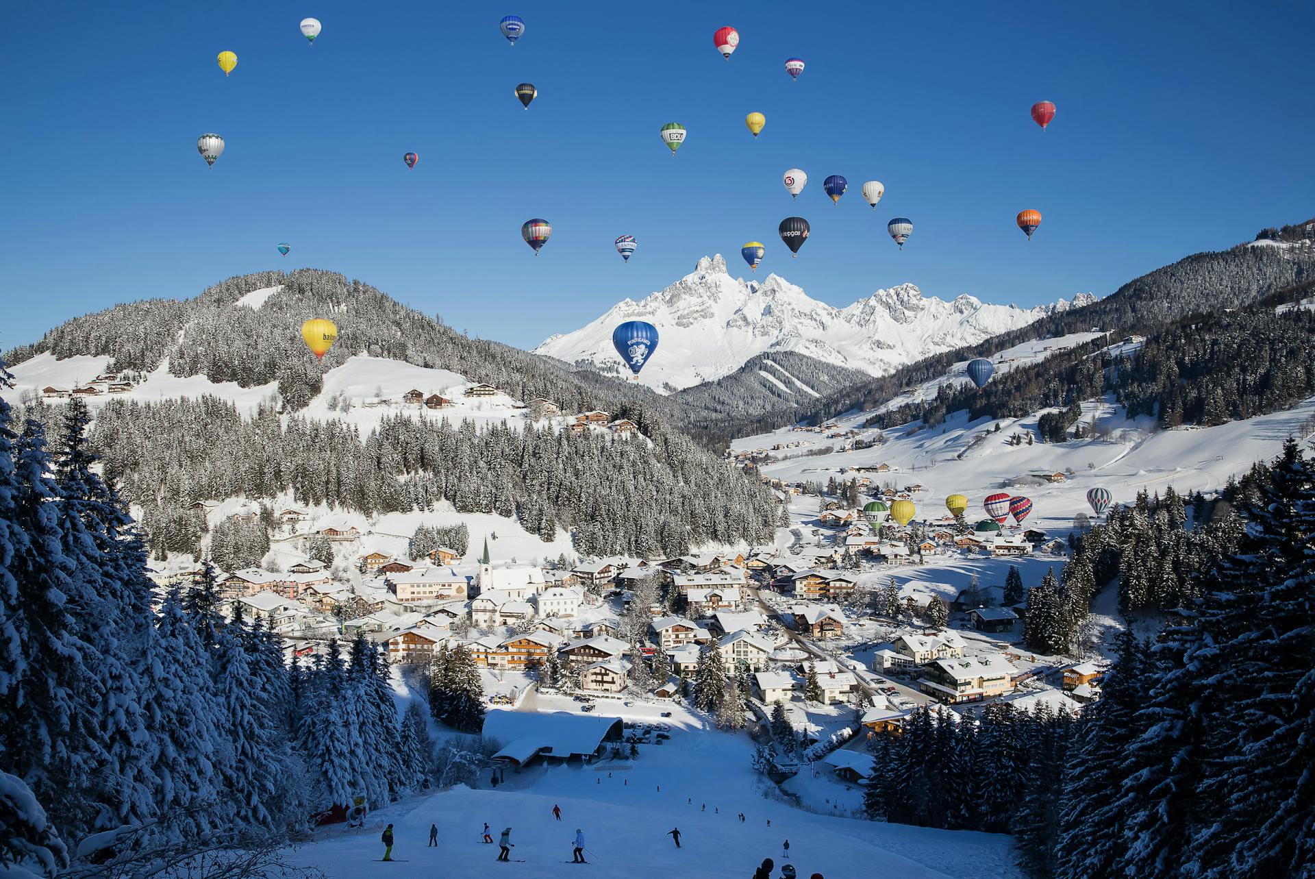 Hot air balloons fly over austrian ski resort of filzmoos