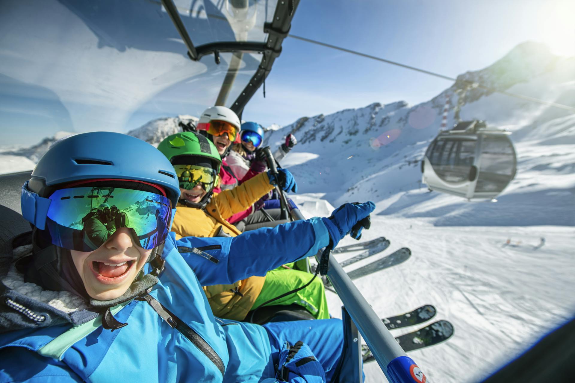 young family of skiers taking selfie on chairlift at ski resort