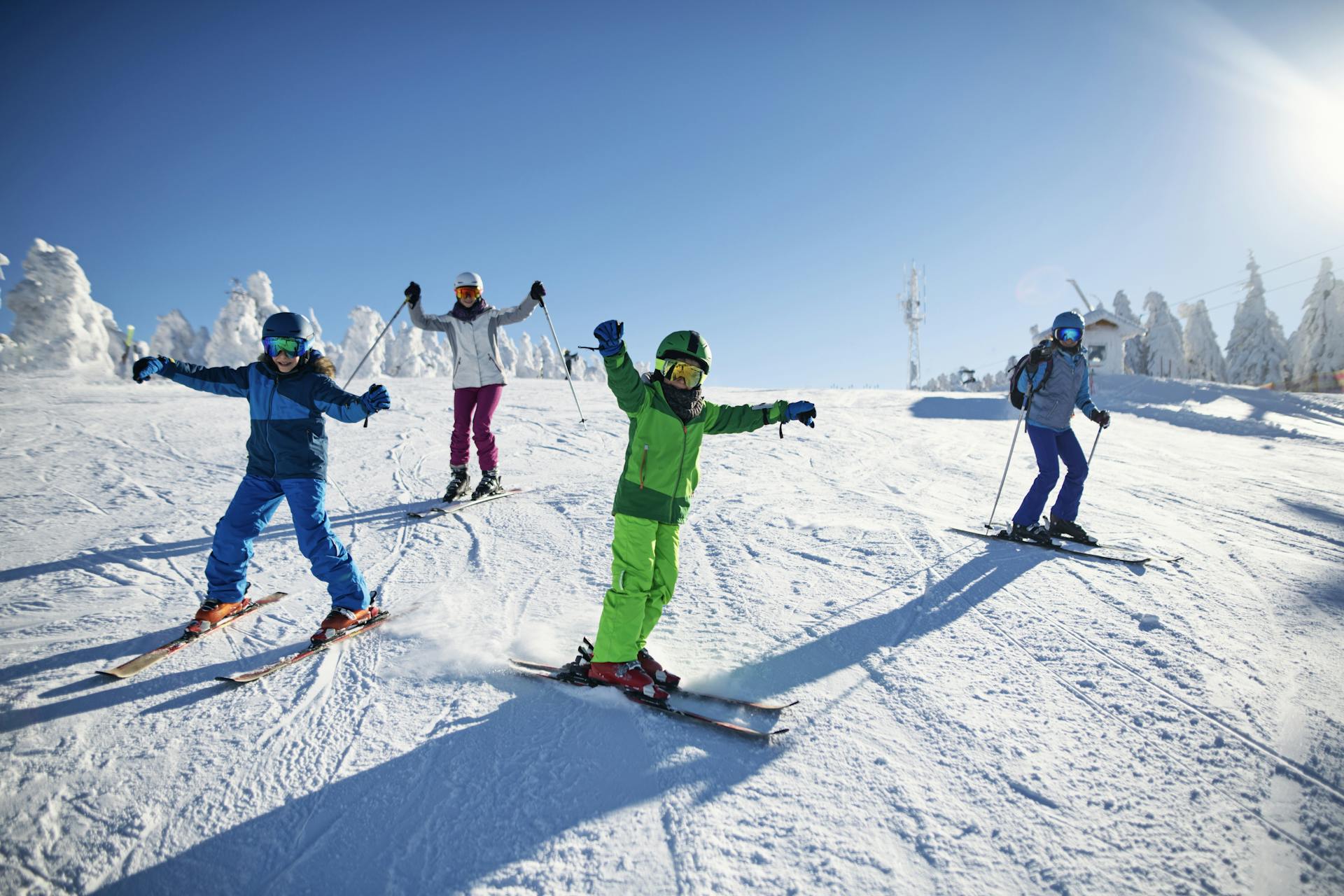 family waving hands in the air while skiing on holiday
