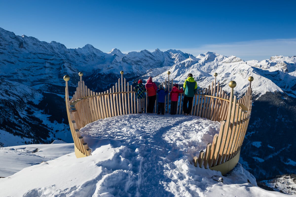 Family enjoying royal walk view of Swiss mountains in Wengen ski resort