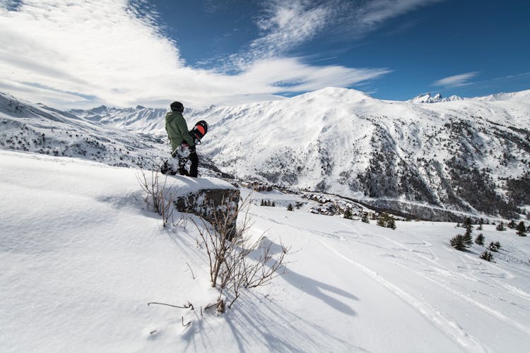 Snowboarder overlooking ski slopes in Valmeinier