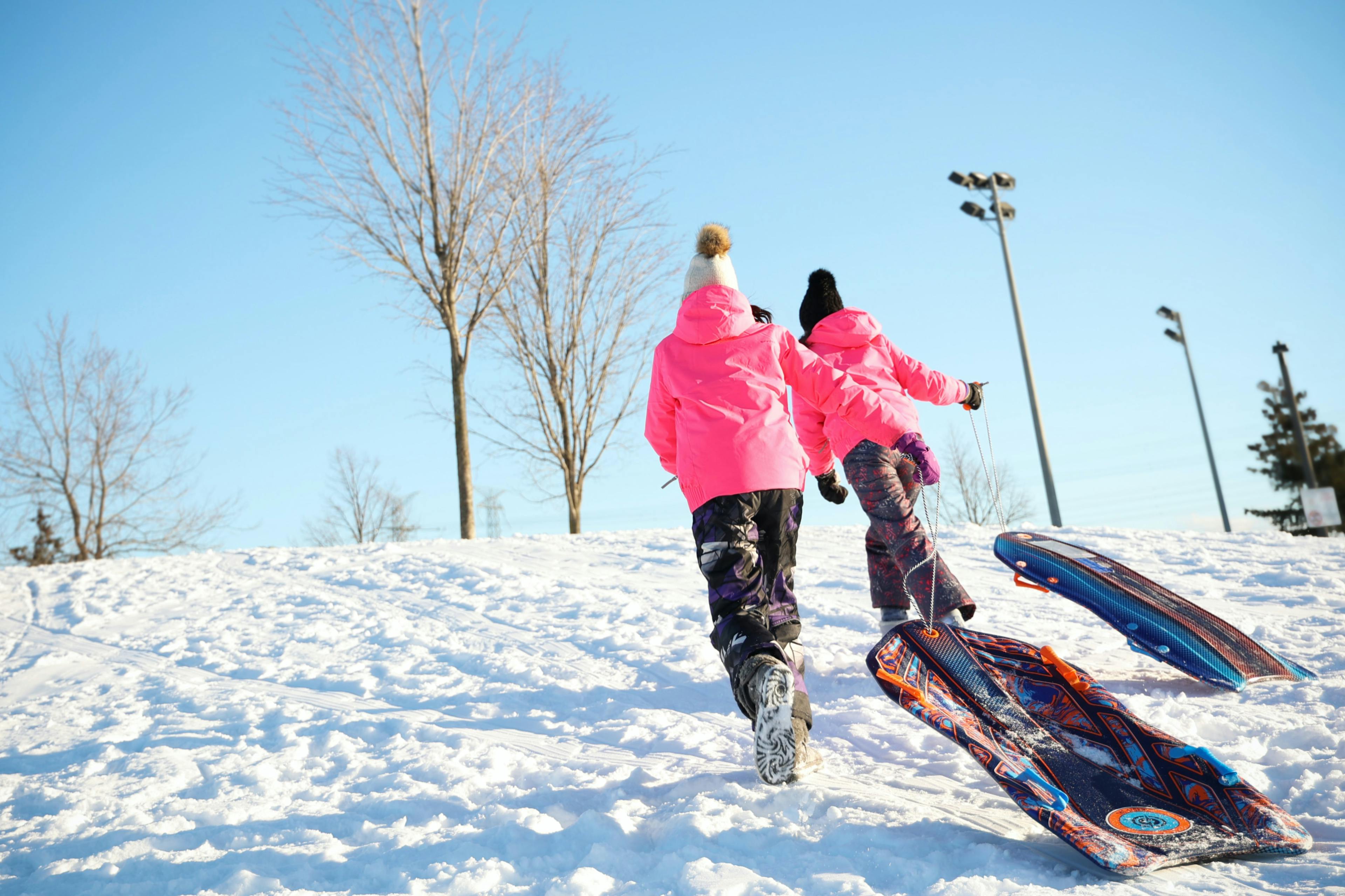 Children having fun in the snow with sledges