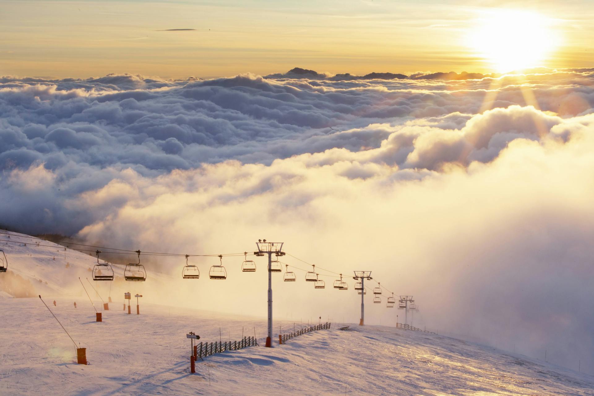 Chairlifts above ski slope at sunset