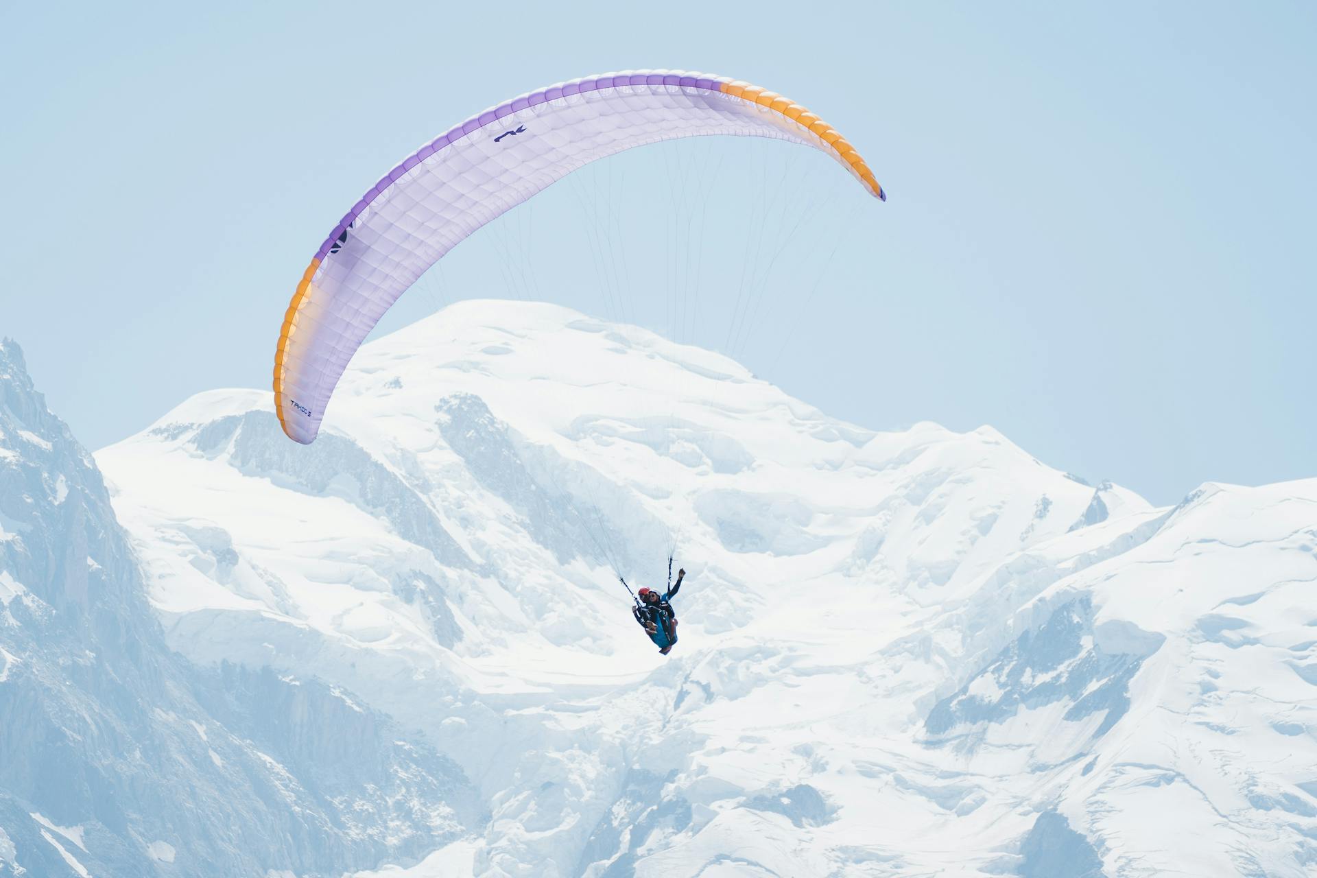 Winter tandem paragliding over snowy mountains in winter