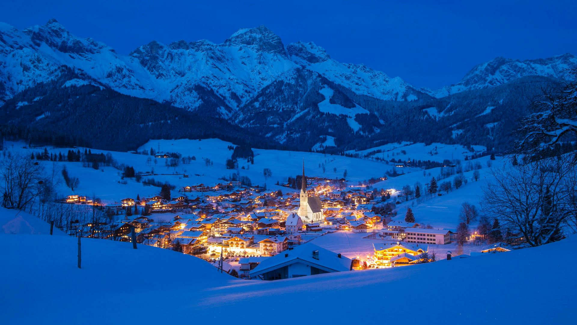Maria Alm ski resort at night with town lit up and mountains in background