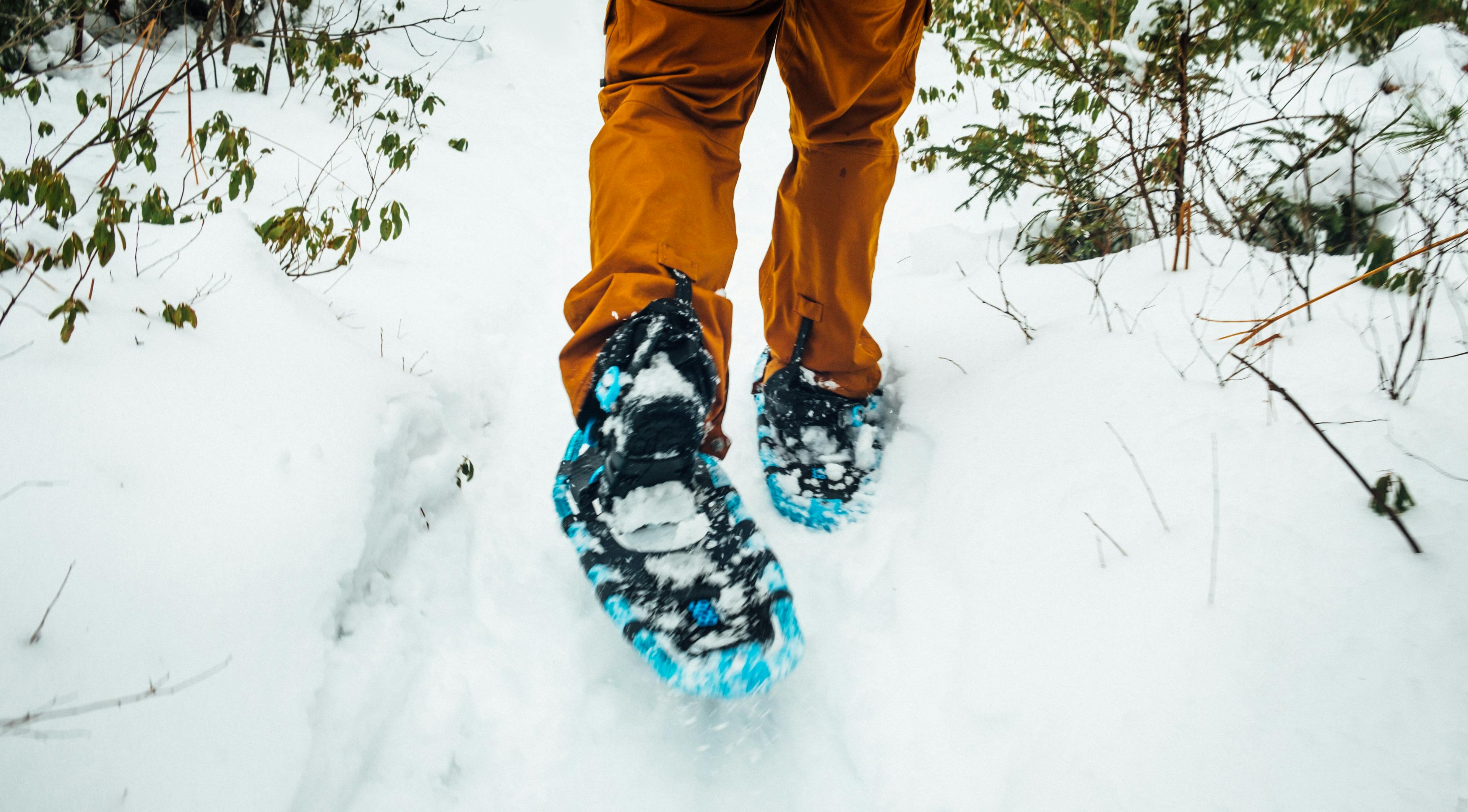 Man using snow shoes to walk over deep snow on holiday