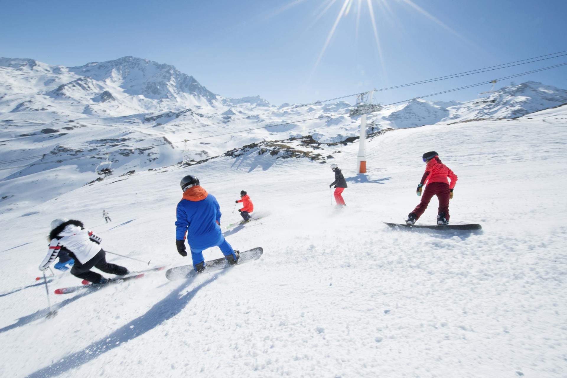 Family skiing and snowboarding together at Val Thorens ski resort