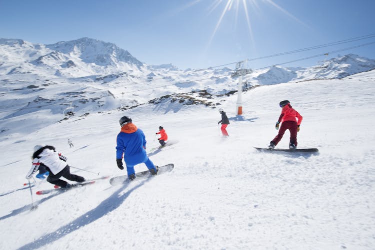 Family skiing down ski slope in Val Thorens Winter resort