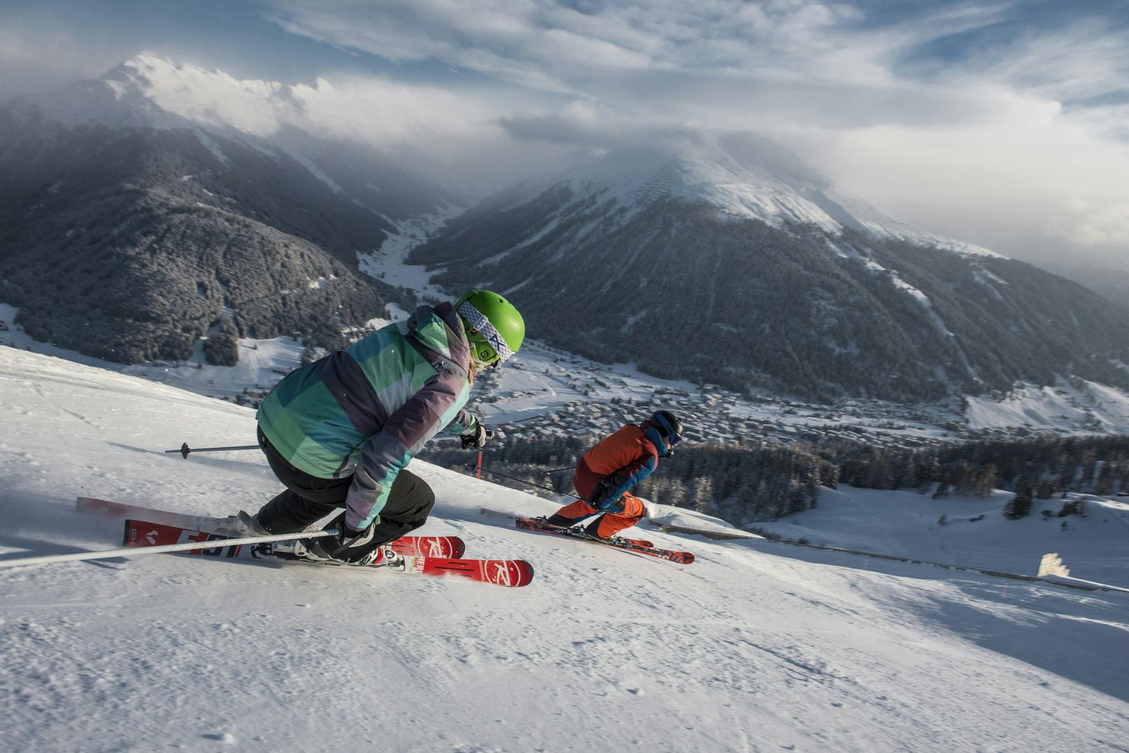 Couple of skiers skiing down piste in Davos ski resort